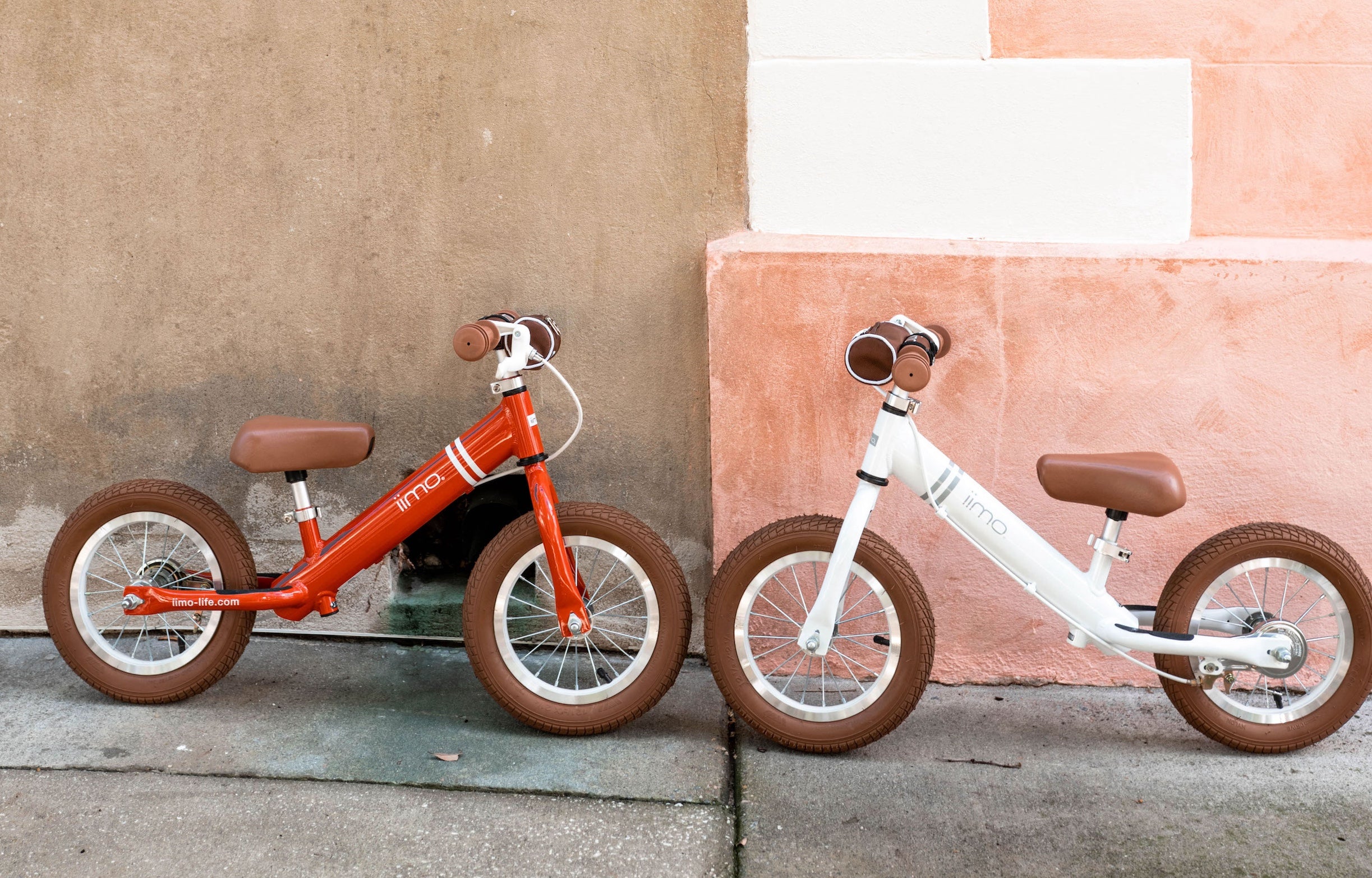 Two children's bikes against a wall