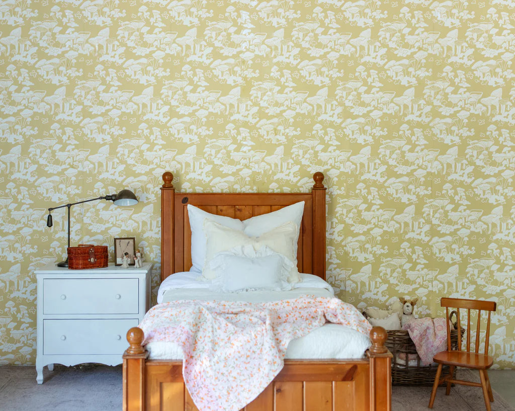 Kid's bed with printed wallpaper behind it