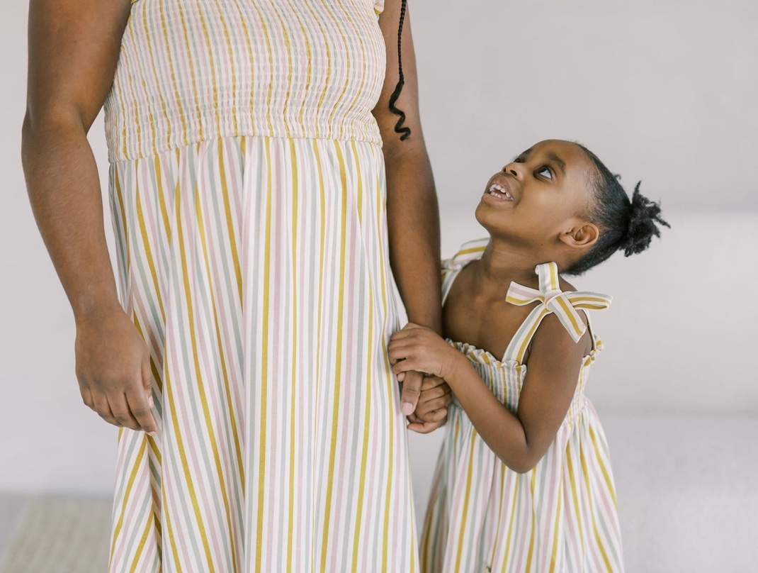 Girl looking at her mother wearing matching dresses