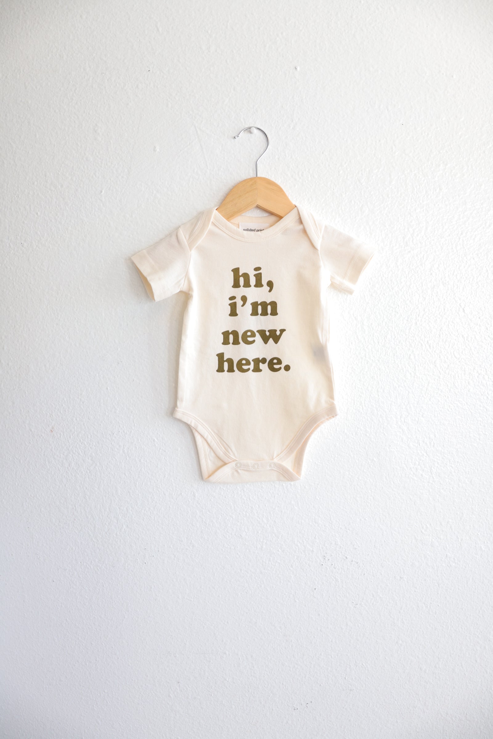 Hi, I’m New Here Baby Onesie in Fir Green Polished Prints   