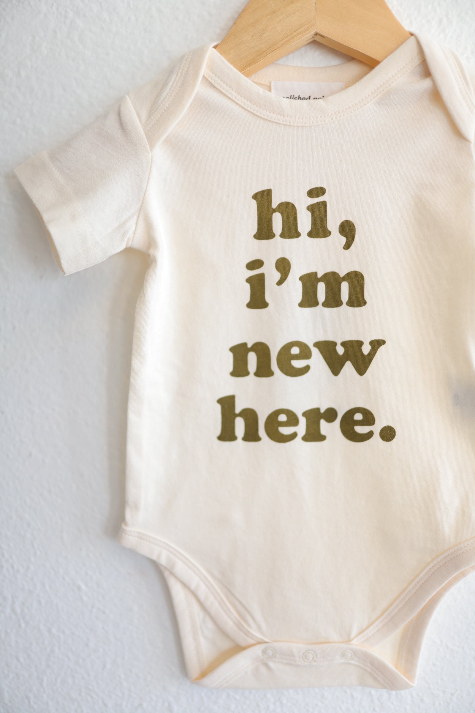 Hi, I’m New Here Baby Onesie in Fir Green Polished Prints   